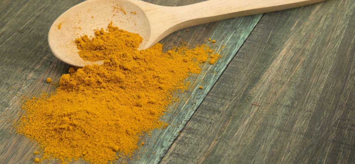 turmeric powder and wooden spoon