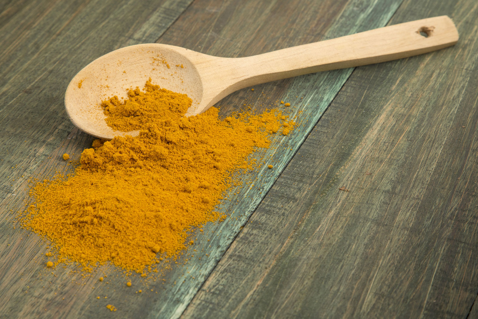 turmeric powder and wooden spoon