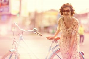 girl laughing next to bicycle